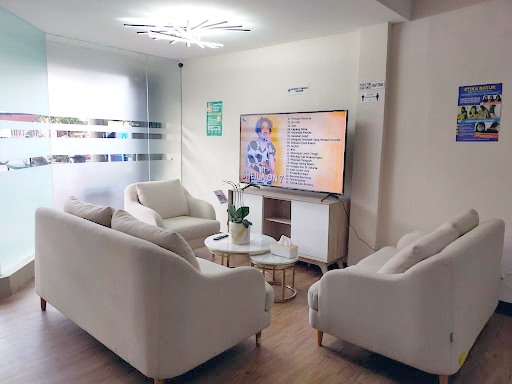 Ruang tunggu Klinik Avalon dengan sofa putih dan televisi